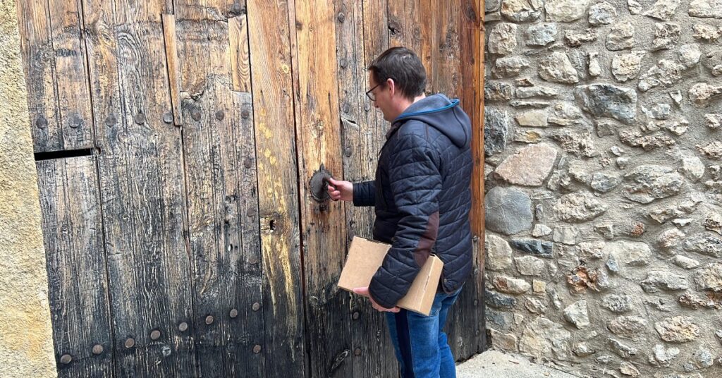 Mario Mata, veí de Tuixent, a punt d'entrar amb un paquet a casa seva (Albert Lijarcio, ACN)