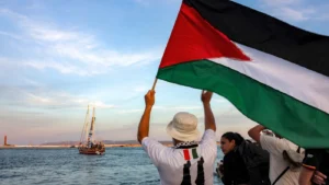 Persona ondeando una bandera palestina en una flotilla hacia Gaza