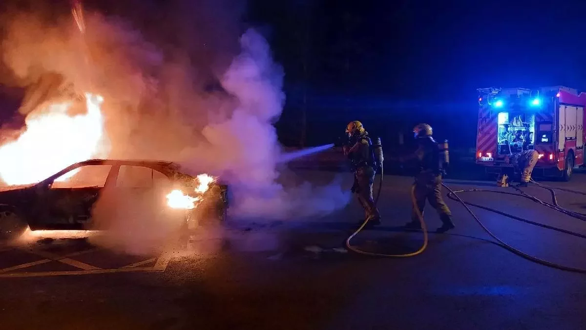 Els bombers, apagant un dels vehicles incendiats a Montferrer.