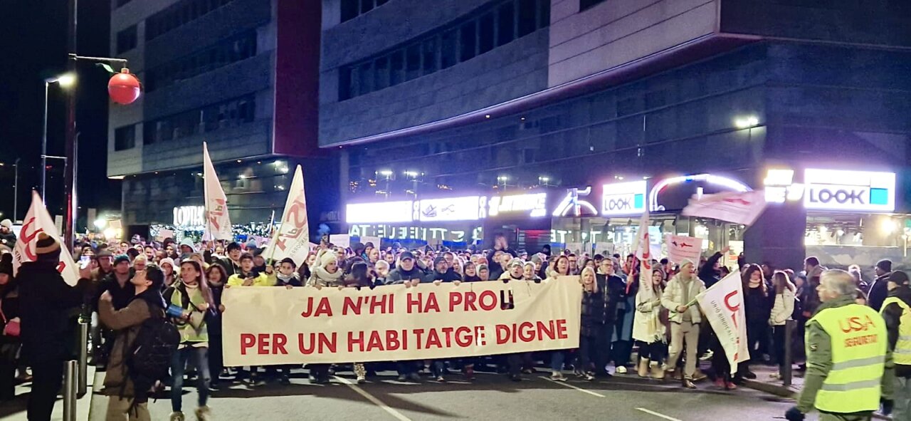 Manifestació per un habitatge digne a Andorra amb pancartes i banderes.