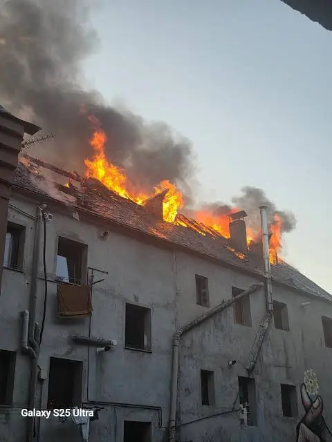 Edifici en flames amb fum negre a la teulada