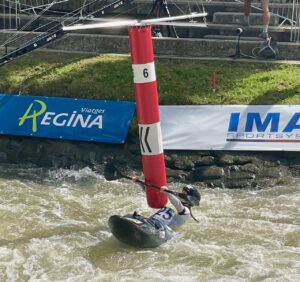 Competidora de caiac superant una porta vermella en una competició al Parc Olímpic del Segre. / La Valira